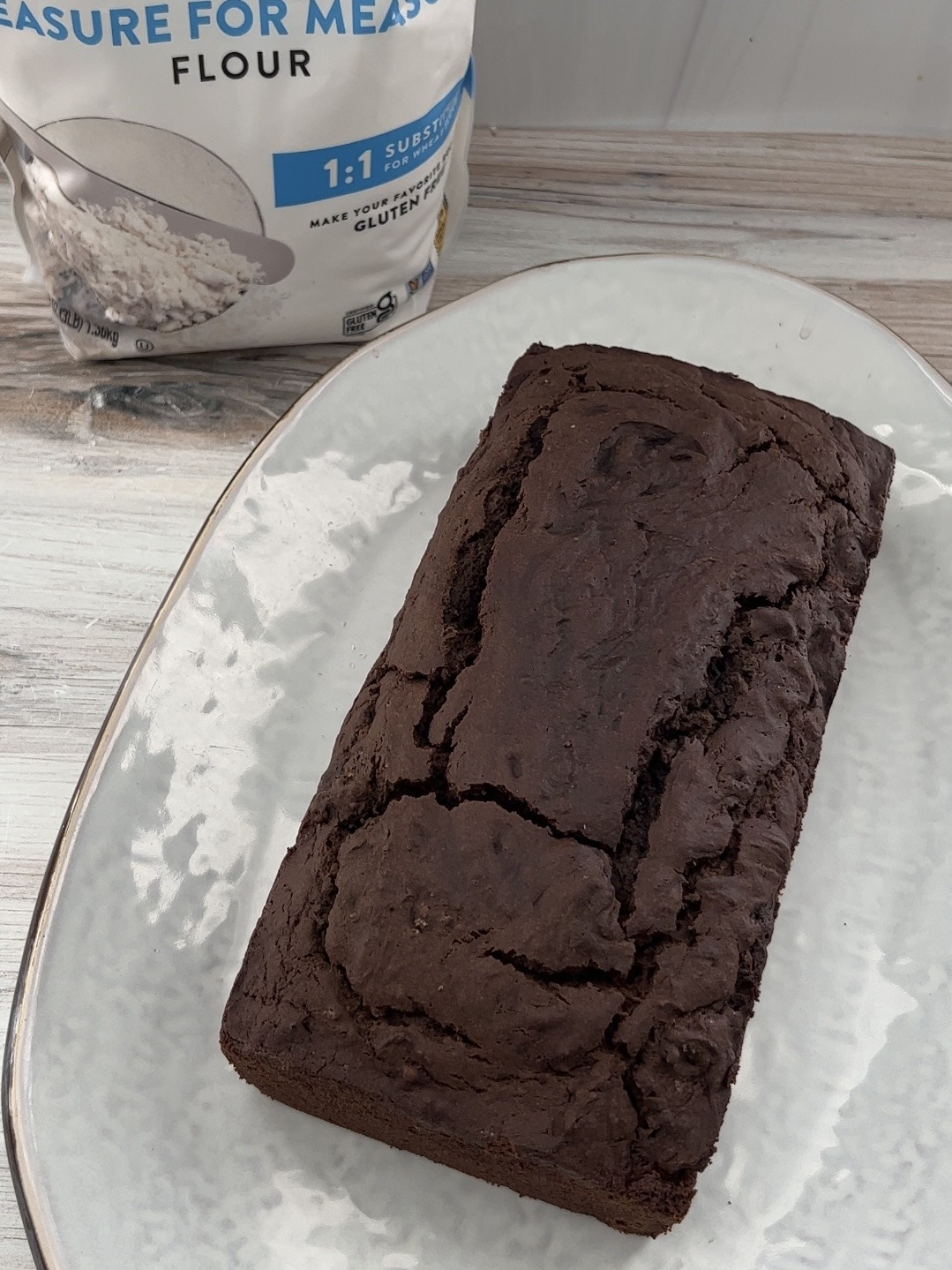 vegan chocolate cake loaf after being baked on a white platter. 