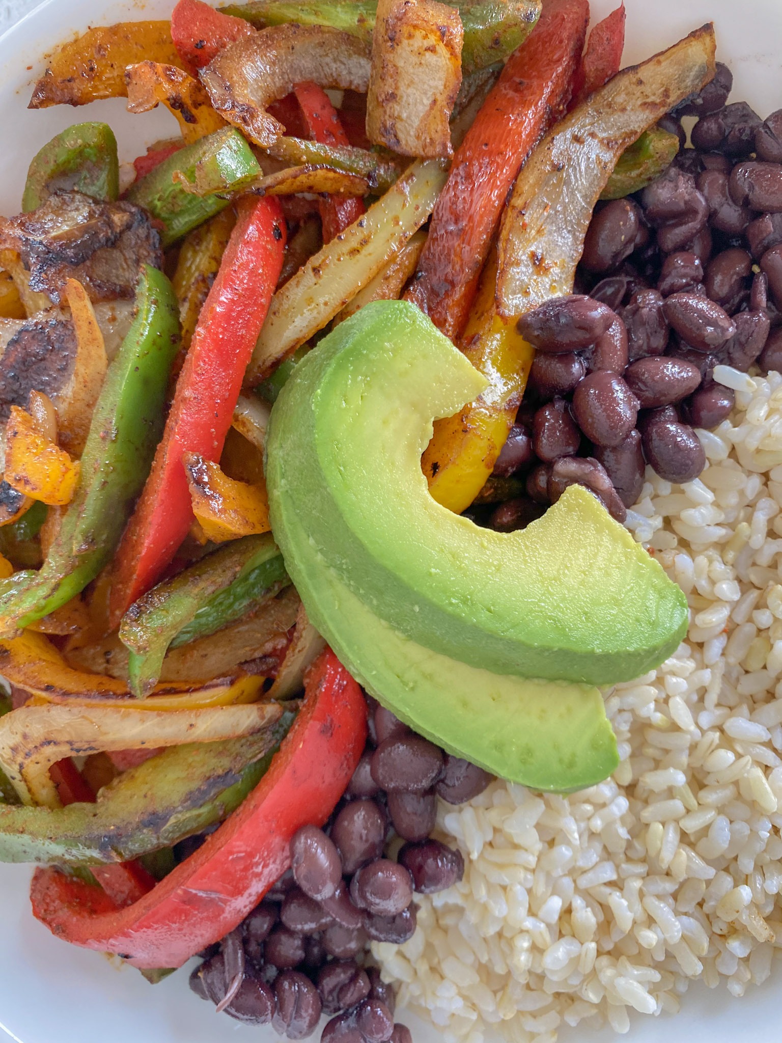 Serving veggie fajitas with rice, black beans and avocado.