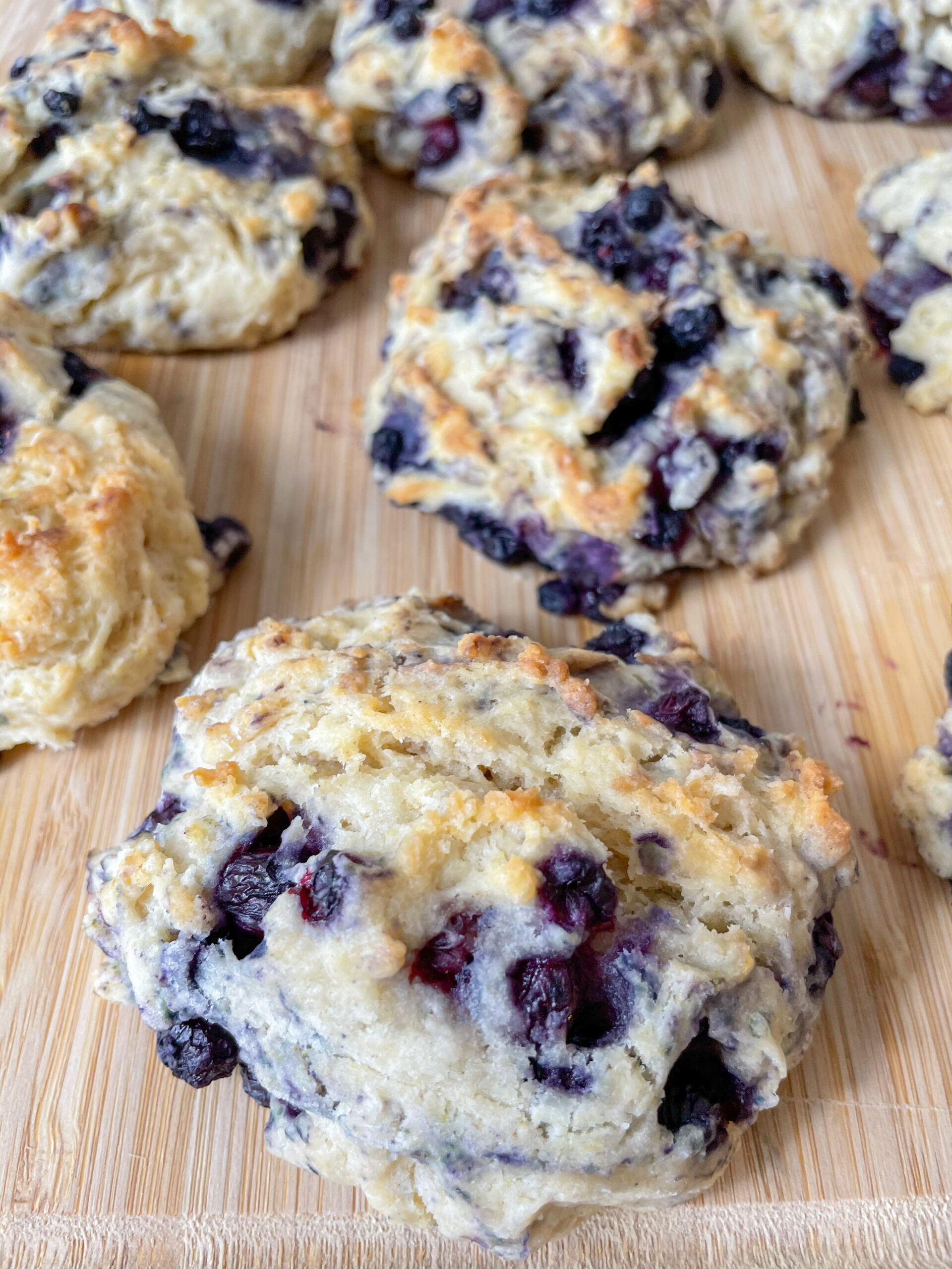 Blueberry biscuits after being baked on a wooden cutting board. 