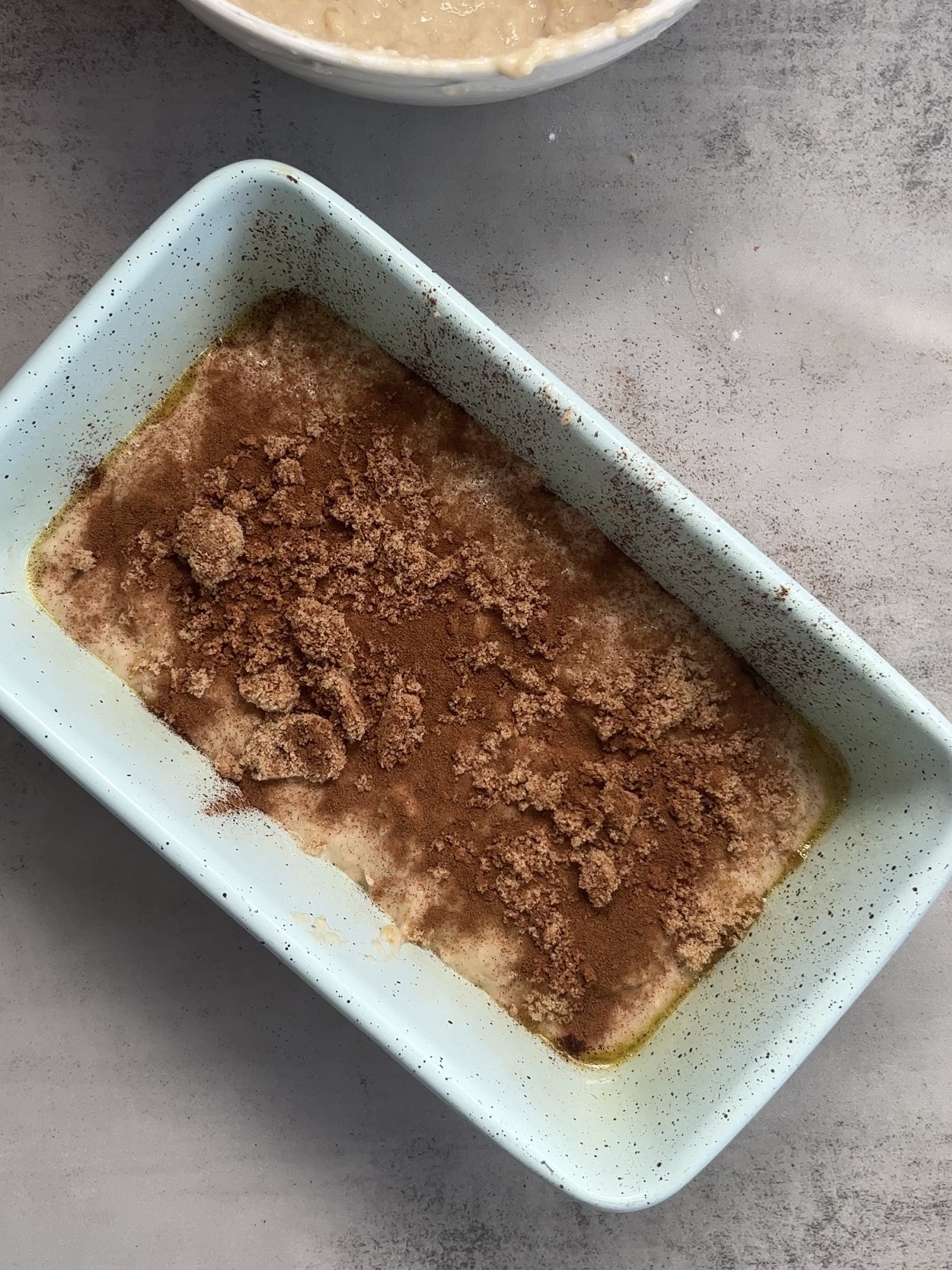 Half of the batter in the loaf pan, topped with cinnamon and brown sugar.