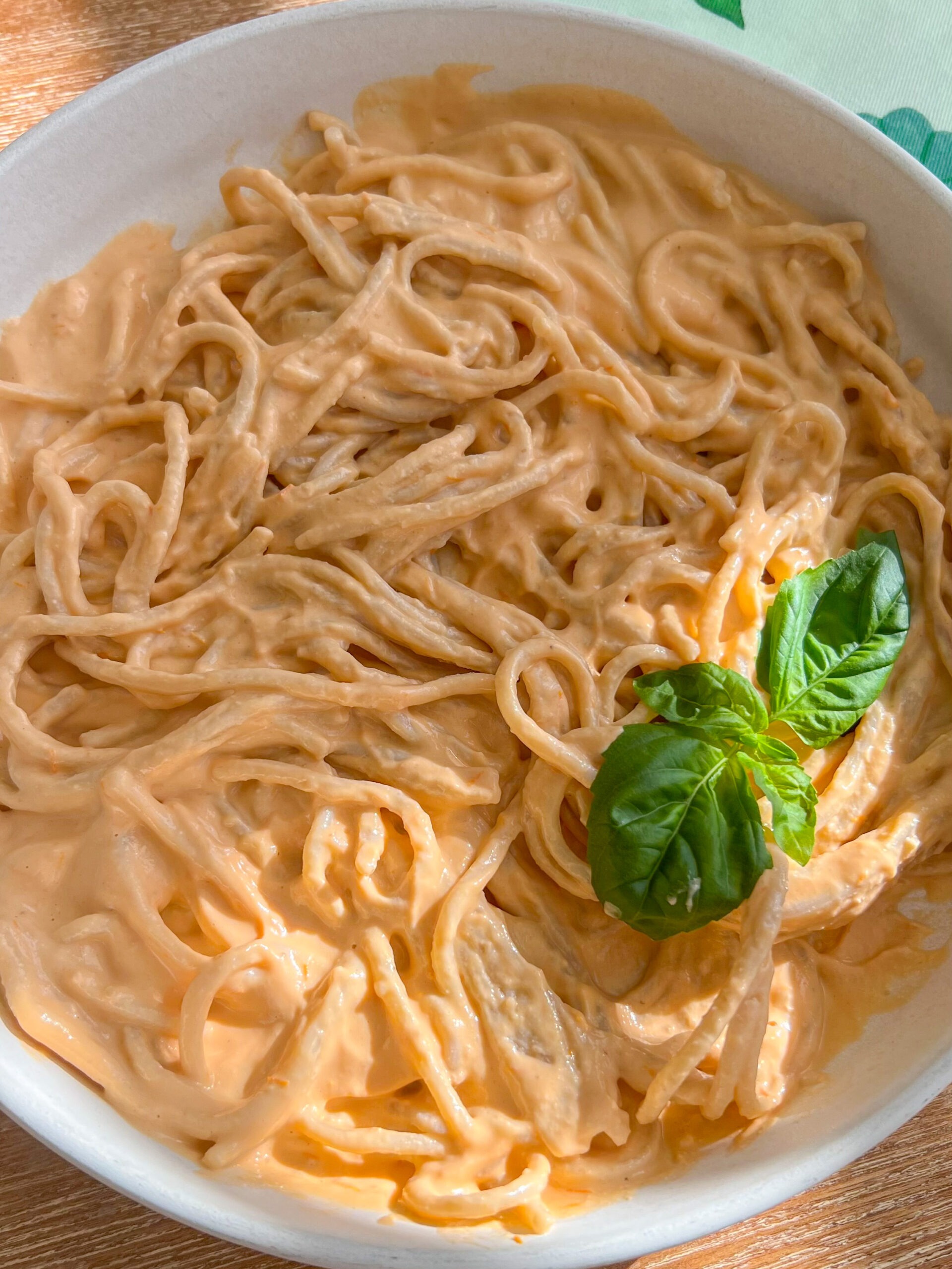 vegan creamy roasted tomato garlic pasta in a white bowl. 