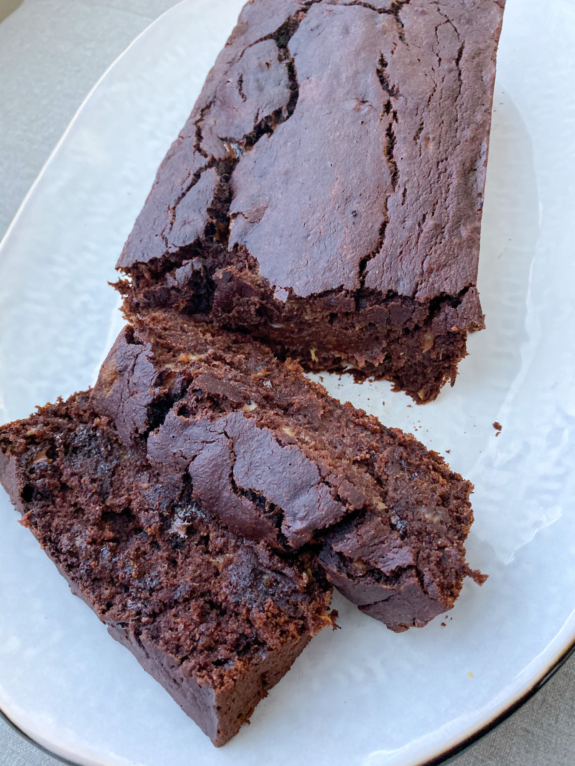 vegan chocolate banana bread loaf with two slices cut off of the end. 