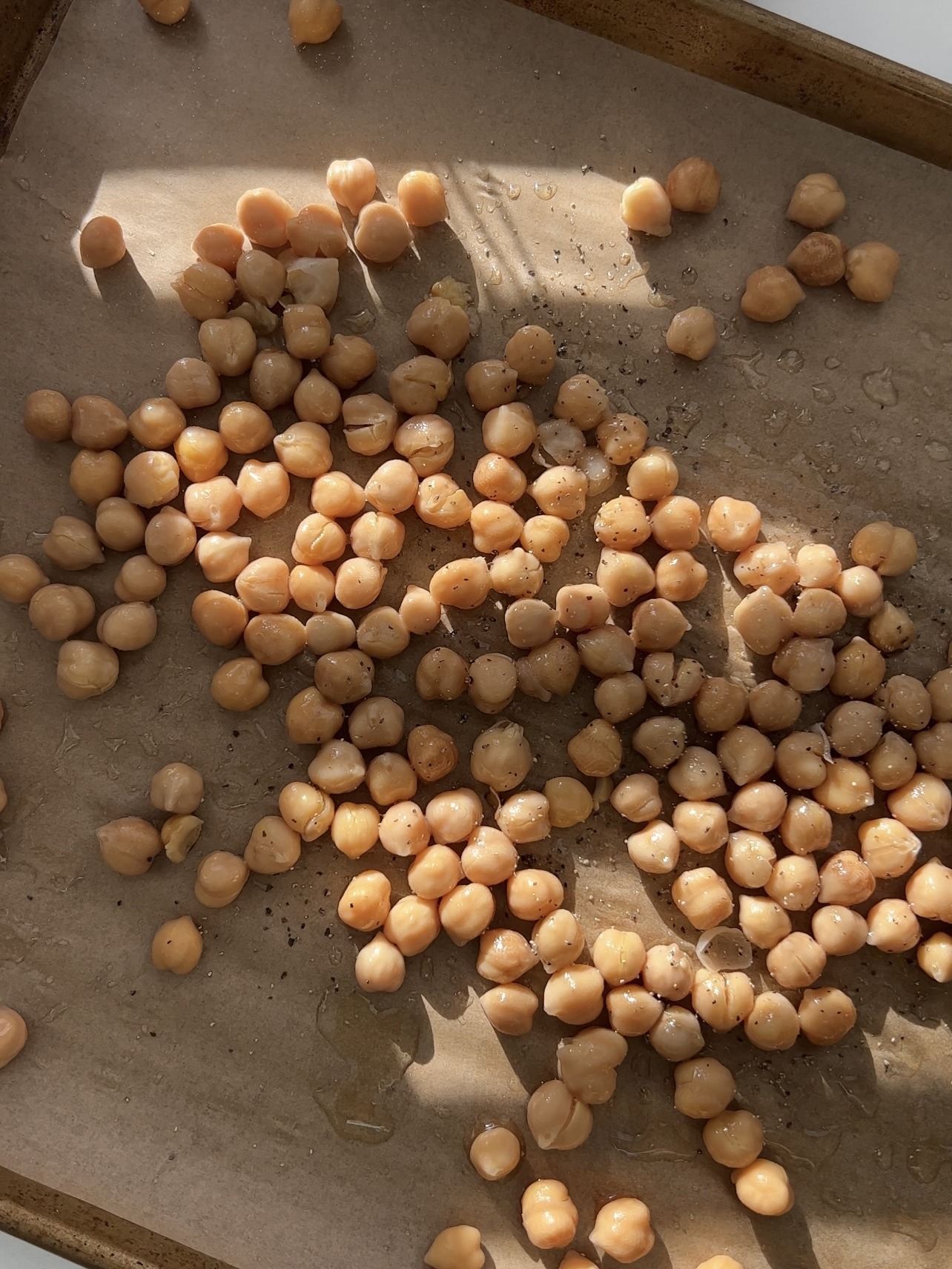 Step 1: To prepare the crispy chickpeas, preheat the oven. Disperse the chickpeas onto a baking sheet lined with parchment paper. Drizzle them with olive oil or avocado oil. Season with salt and pepper. Bake in the oven until crispy.