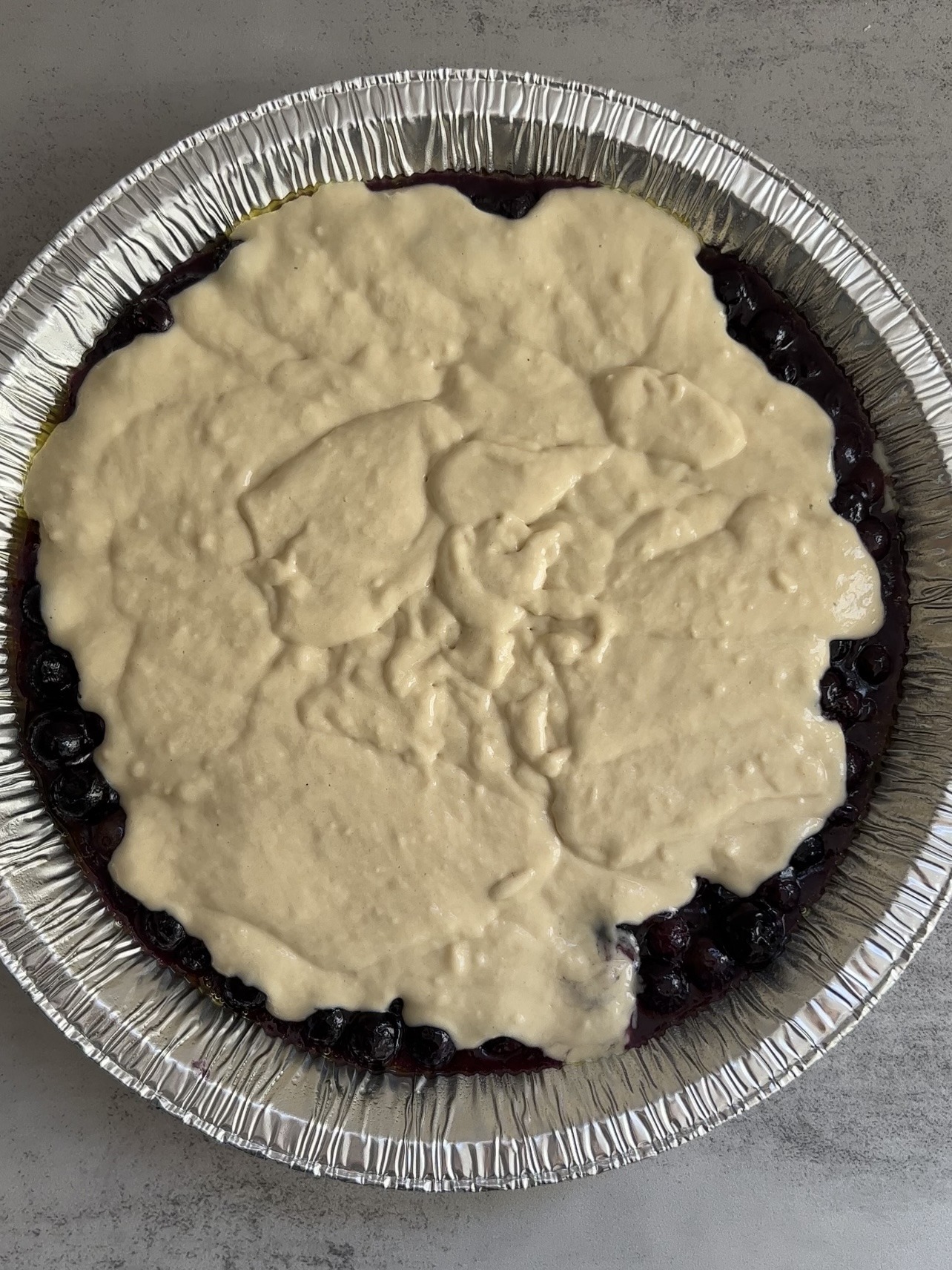 blueberry cobbler with the batter on top before baking