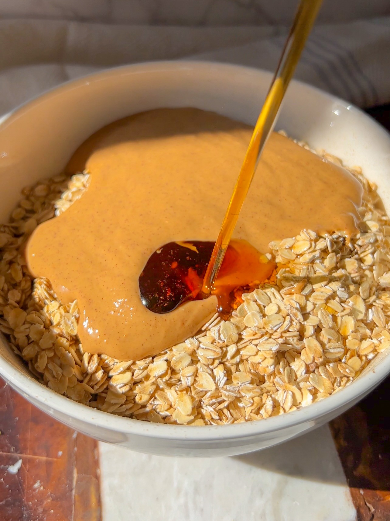 peanut butter granola (pouring the maple syrup and peanut butter over the cereal and oats)