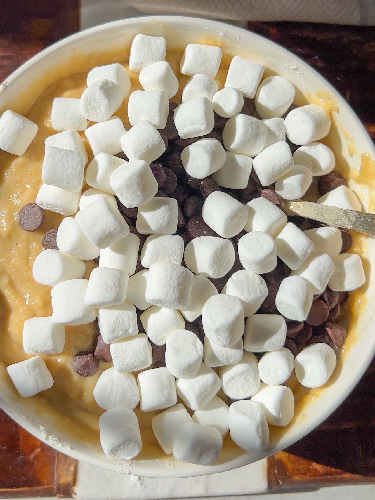 folding the marshmallows and chocolate chips into the banana bread batter