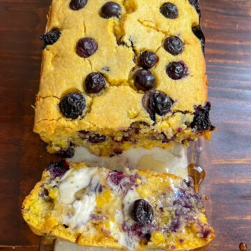 blueberry cornbread spread with butter and drizzled with agave