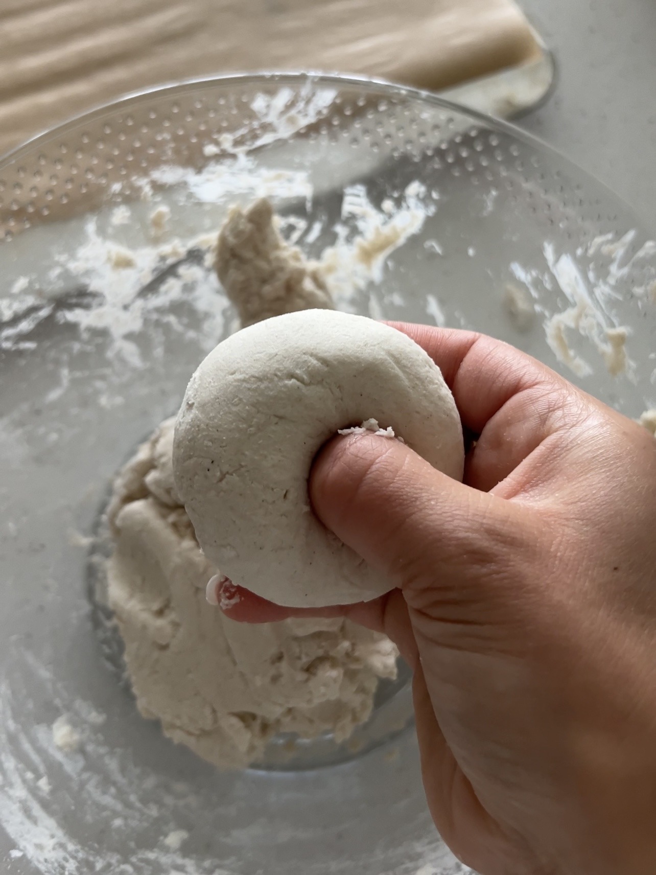 Step 2: Mix the 2 ingredient bagel dough by using a fork to mix the non dairy yogurt and flour together until a thick dough forms. If the dough is too wet and sticky, add another 2-4 tablespoon of flour until it rolls easily. Use your hands to roll about ¼ cup of dough into a 6 inch log shape. Join the ends to create a circle/bagel shape. Place each bagel onto a baking sheet lined with parchment paper.