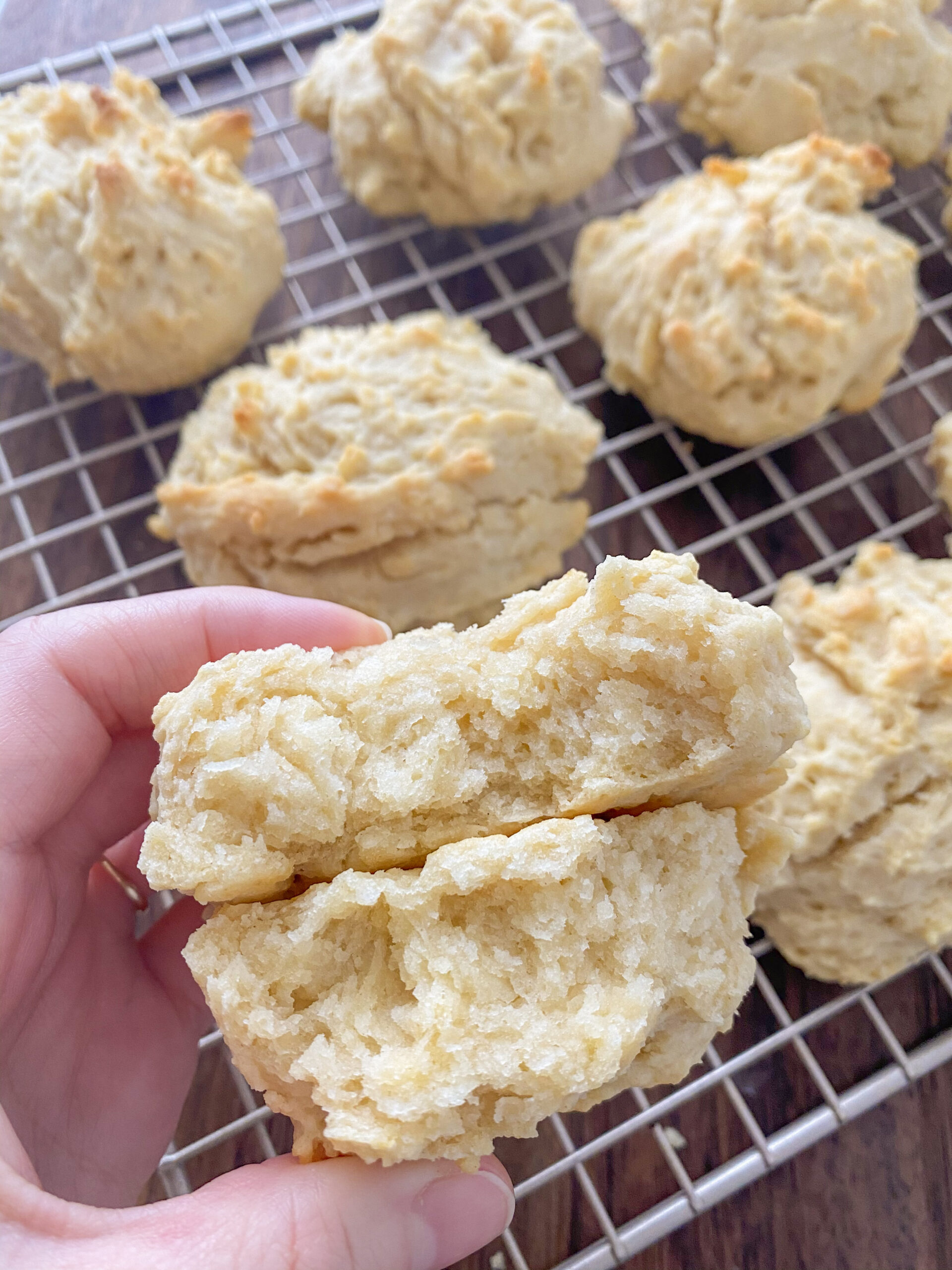 Woman holding a biscuit that is cut in half.