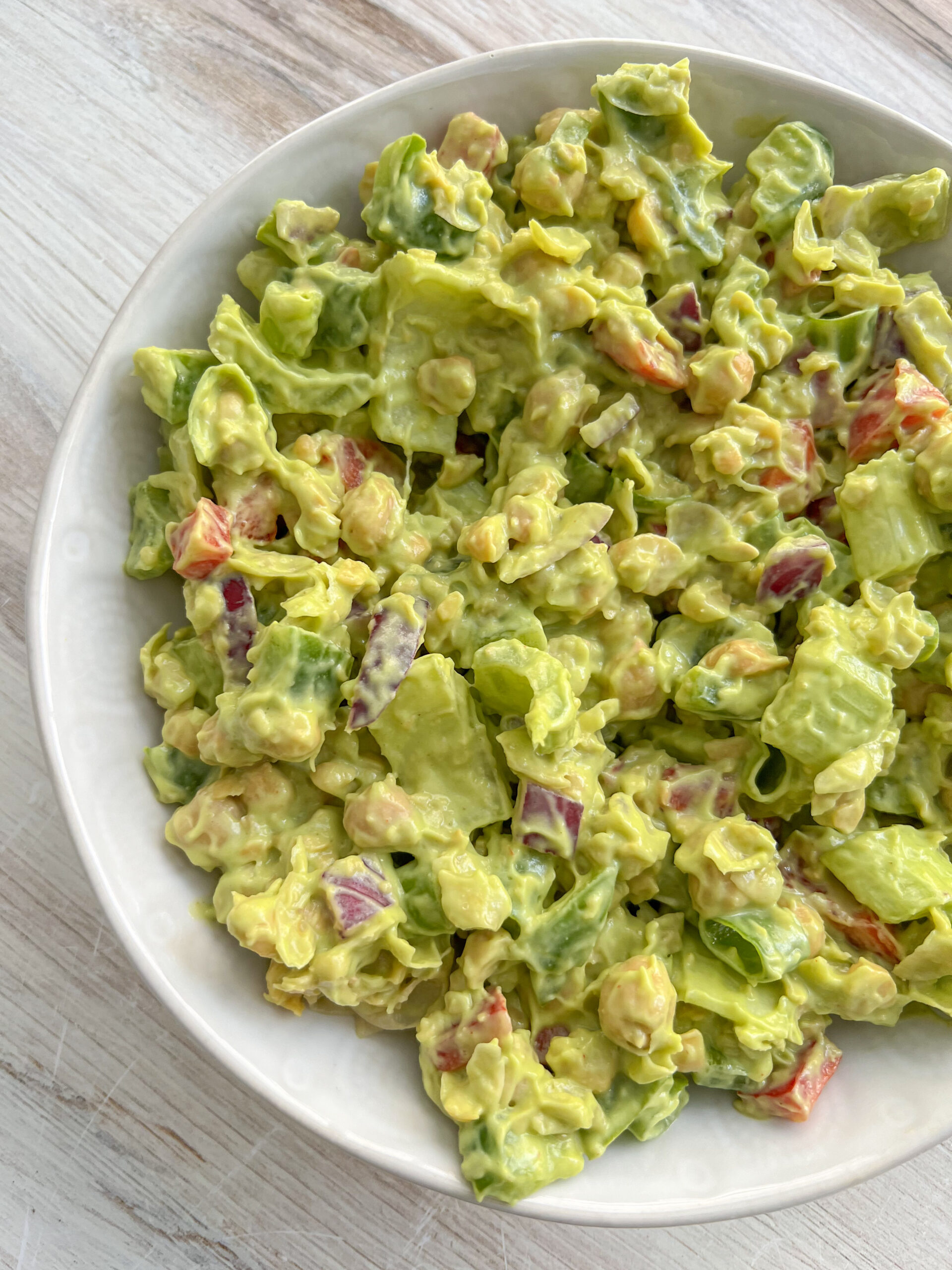 chickpea and avocado salad in a white bowl. 