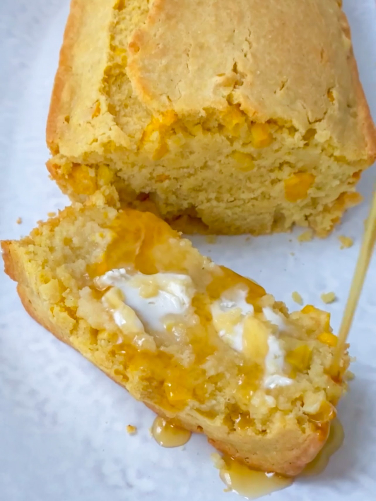 Slice of cornbread with butter and maple syrup.