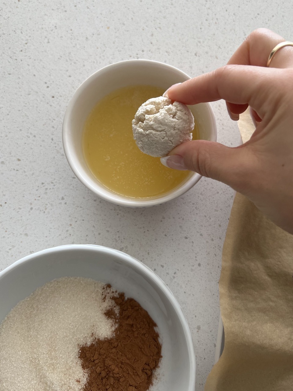 Bagel bite being dipped in melted butter. 