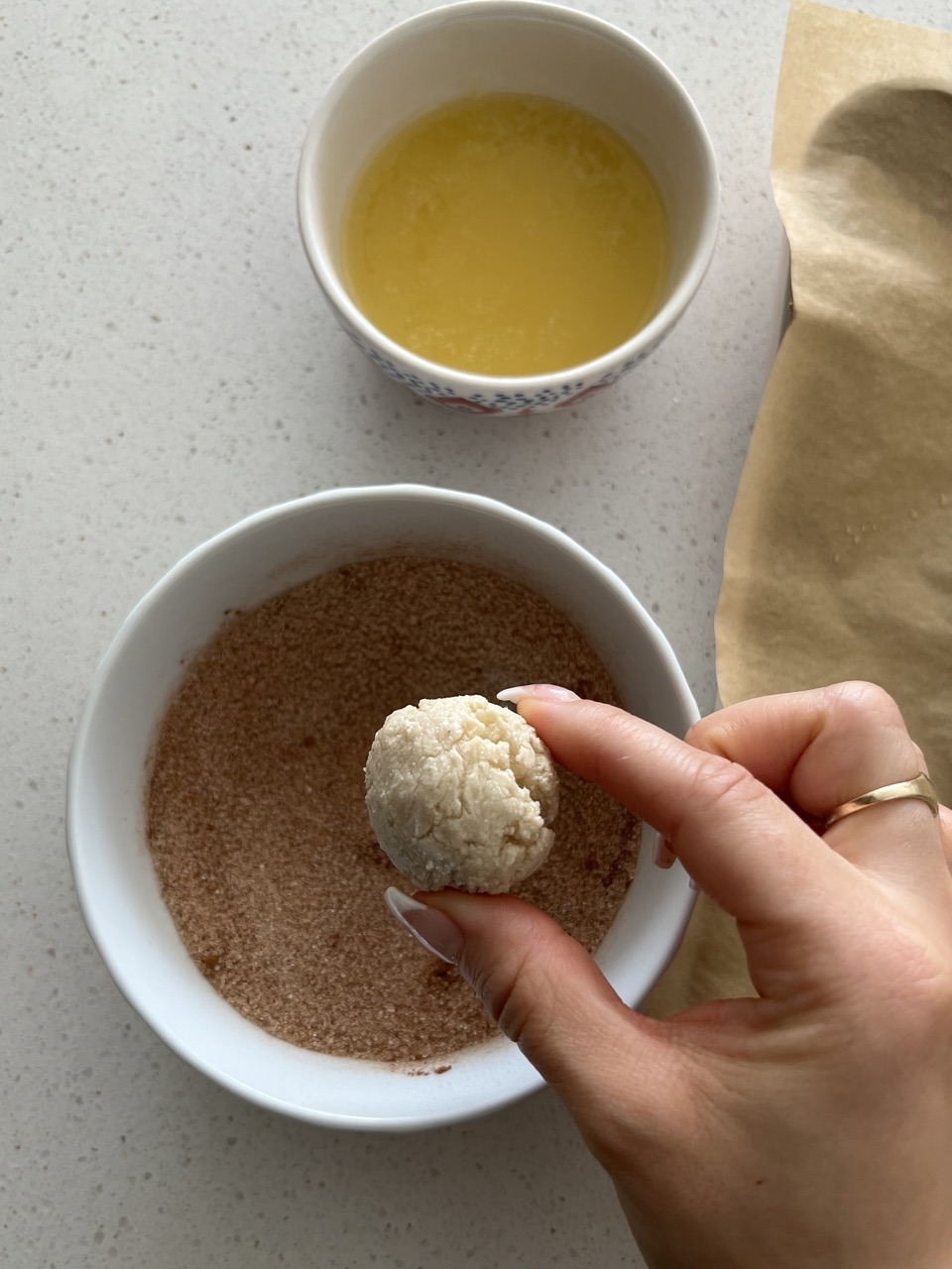 Bagel bite being dipped in cinnamon sugar. 