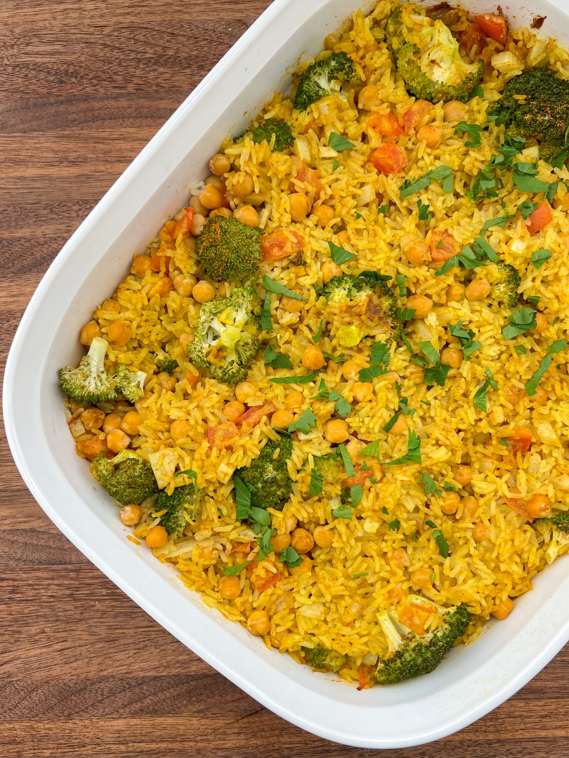 Top view of baked casserole in a white baking dish with a wooden background. 