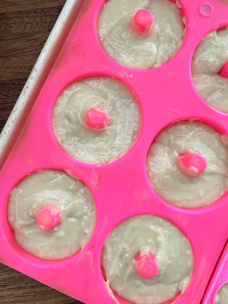 Transferring donut batter to molds.