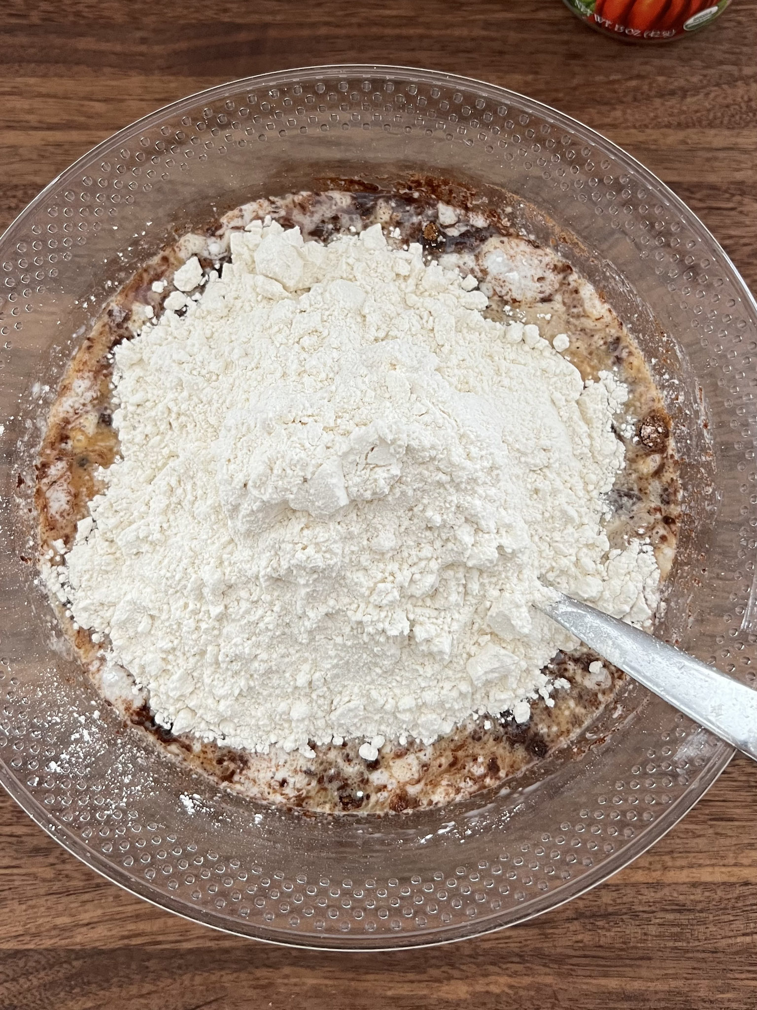 Mixing flour with wet ingredients in a large bowl.