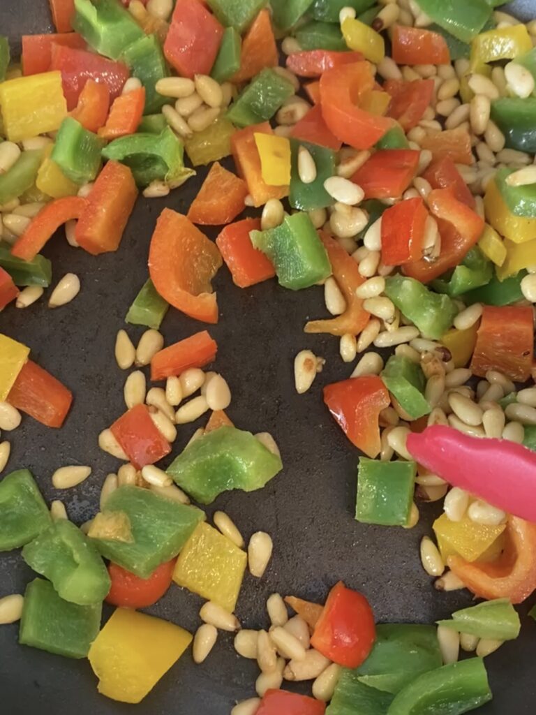 Peppers and nuts being sautéed. 