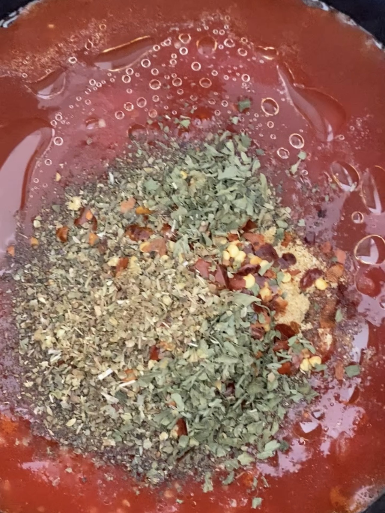 Adding seasonings to tomato basil soup.