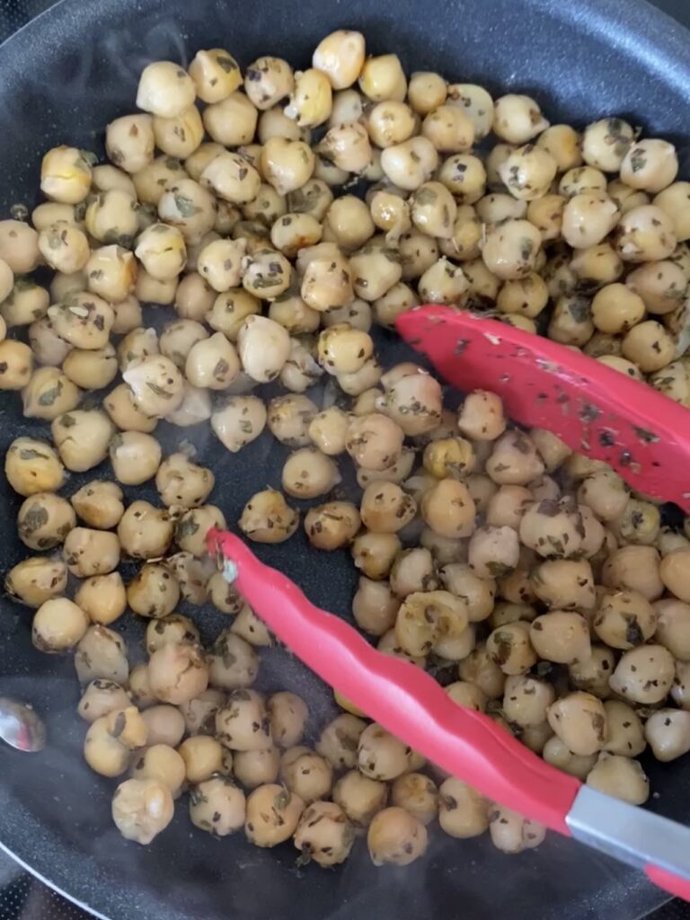 Cooking chickpeas in a skillet.