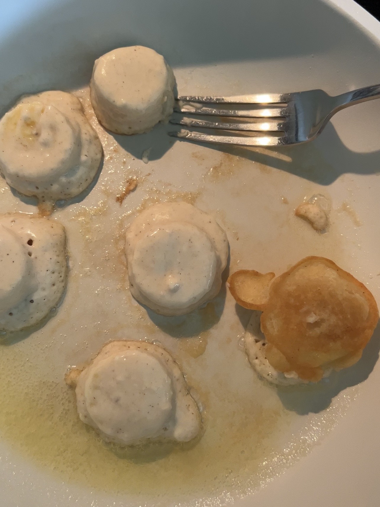 Banana pancakes bites cooking in a sauté pan. 