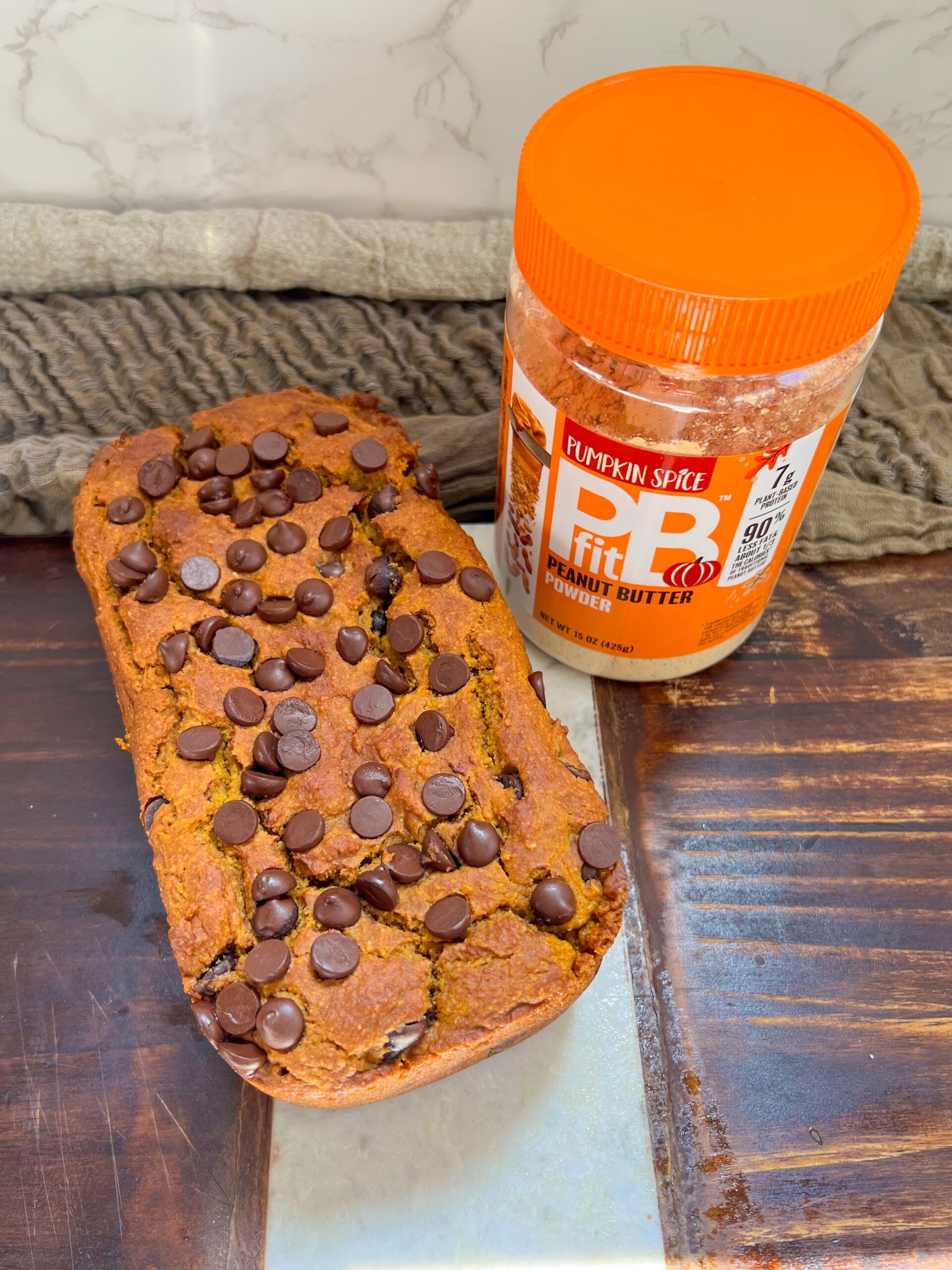 peanut butter pumpkin bread next to a jar of pbfit