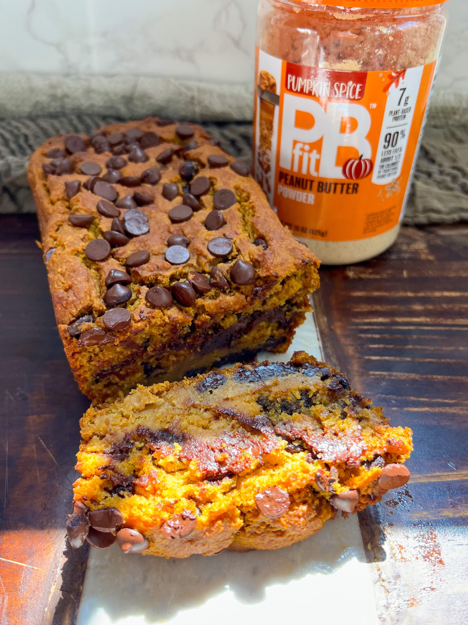 peanut butter pumpkin bread - sliced - next to a jar of pbfit