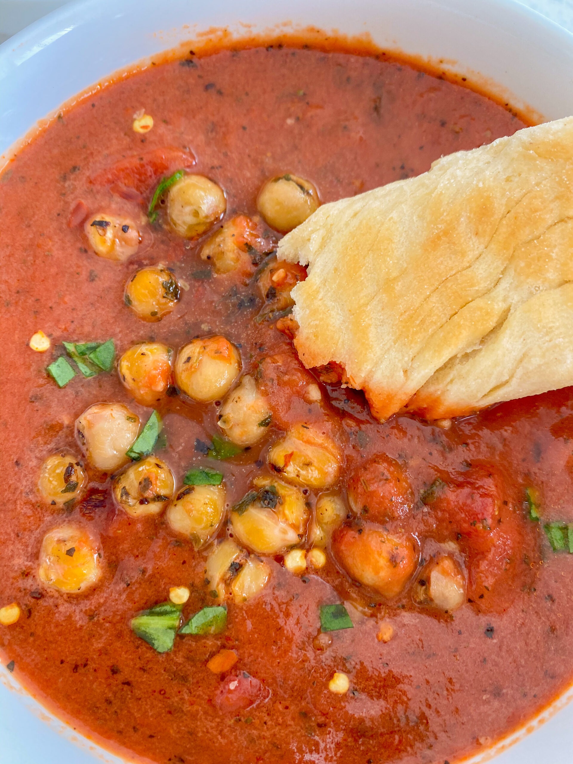 Tomato soup with crispy chickpeas and a breadstick.