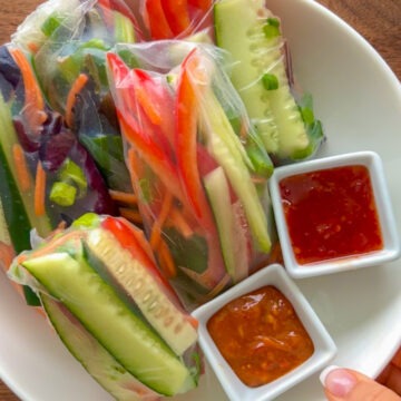 If you're looking for a healthy, fresh, and delicious plant-based meal to make this spring or summer, give these Fresh Vegan Spring Rolls with Homemade Peanut Sauce or Sweet Chili Sriracha Sauce a try! This recipe is super easy, is completely vegan, gluten free, and these wraps will definitely fill you up. I've made these for vegans and non-vegans alike. Everyone loves them and no one can believe how easy they are!