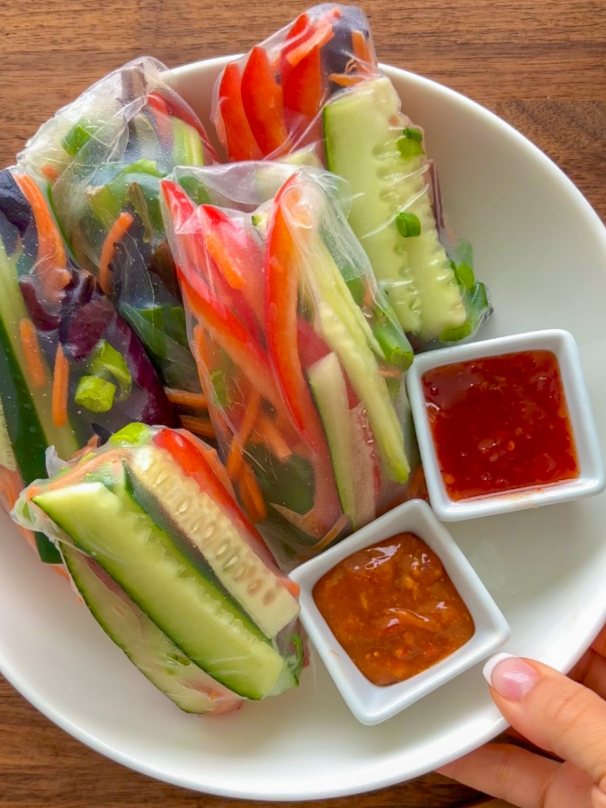 If you're looking for a healthy, fresh, and delicious plant-based meal to make this spring or summer, give these Fresh Vegan Spring Rolls with Homemade Peanut Sauce or Sweet Chili Sriracha Sauce a try! This recipe is super easy, is completely vegan, gluten free, and these wraps will definitely fill you up. I've made these for vegans and non-vegans alike. Everyone loves them and no one can believe how easy they are!