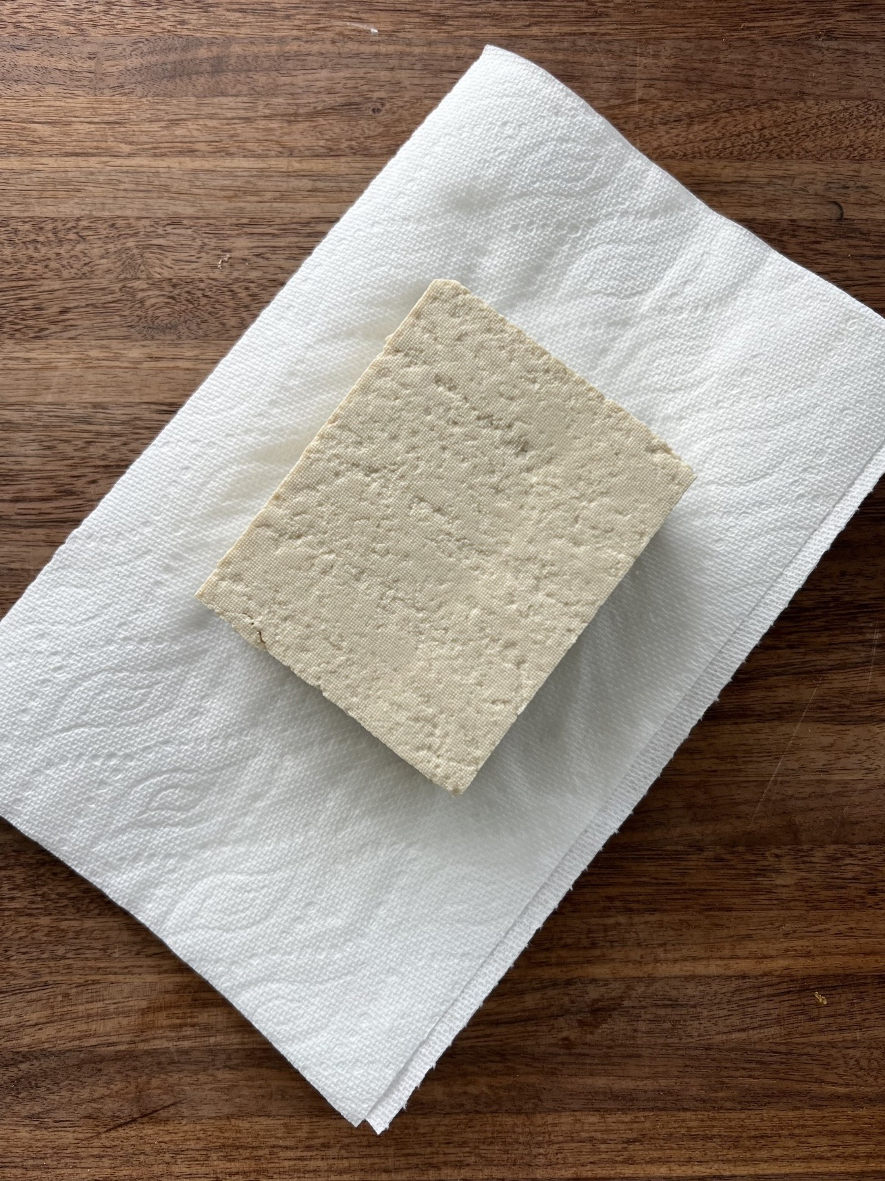 extra firm tofu sitting on top of paper towels 