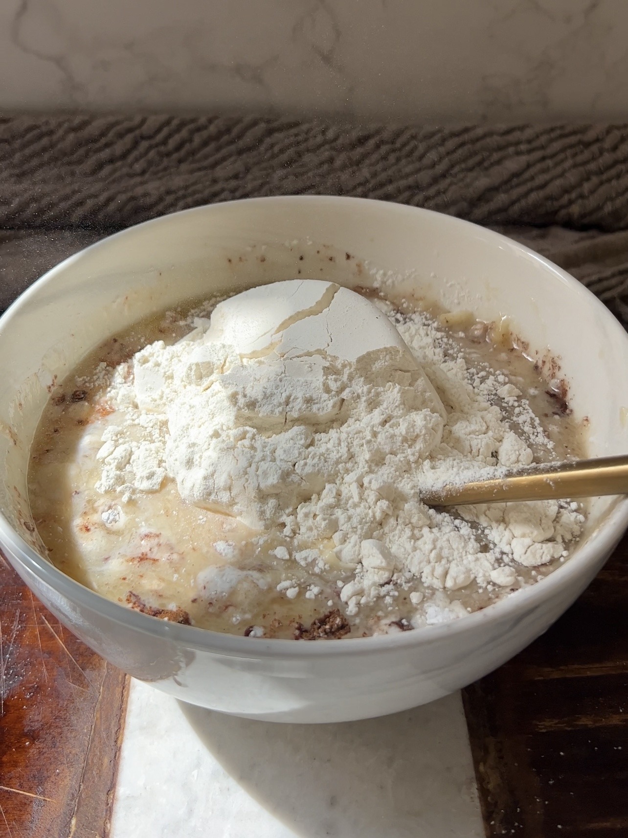 mixing the wet ingredients in with the mashed bananas