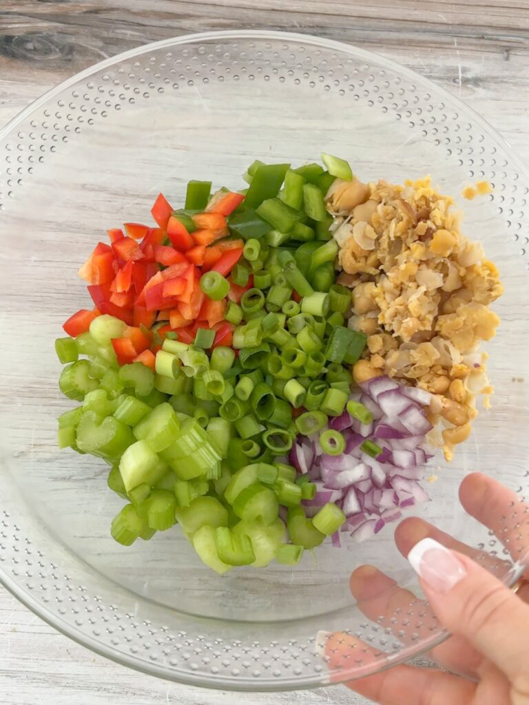 Chopped vegetables and chickpeas in a mixing bowl. 