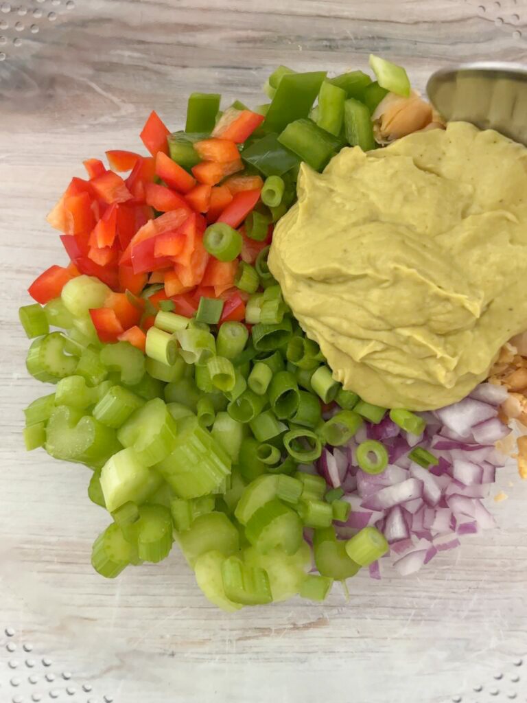 Chopped vegetables and chickpeas in a mixing bowl. 