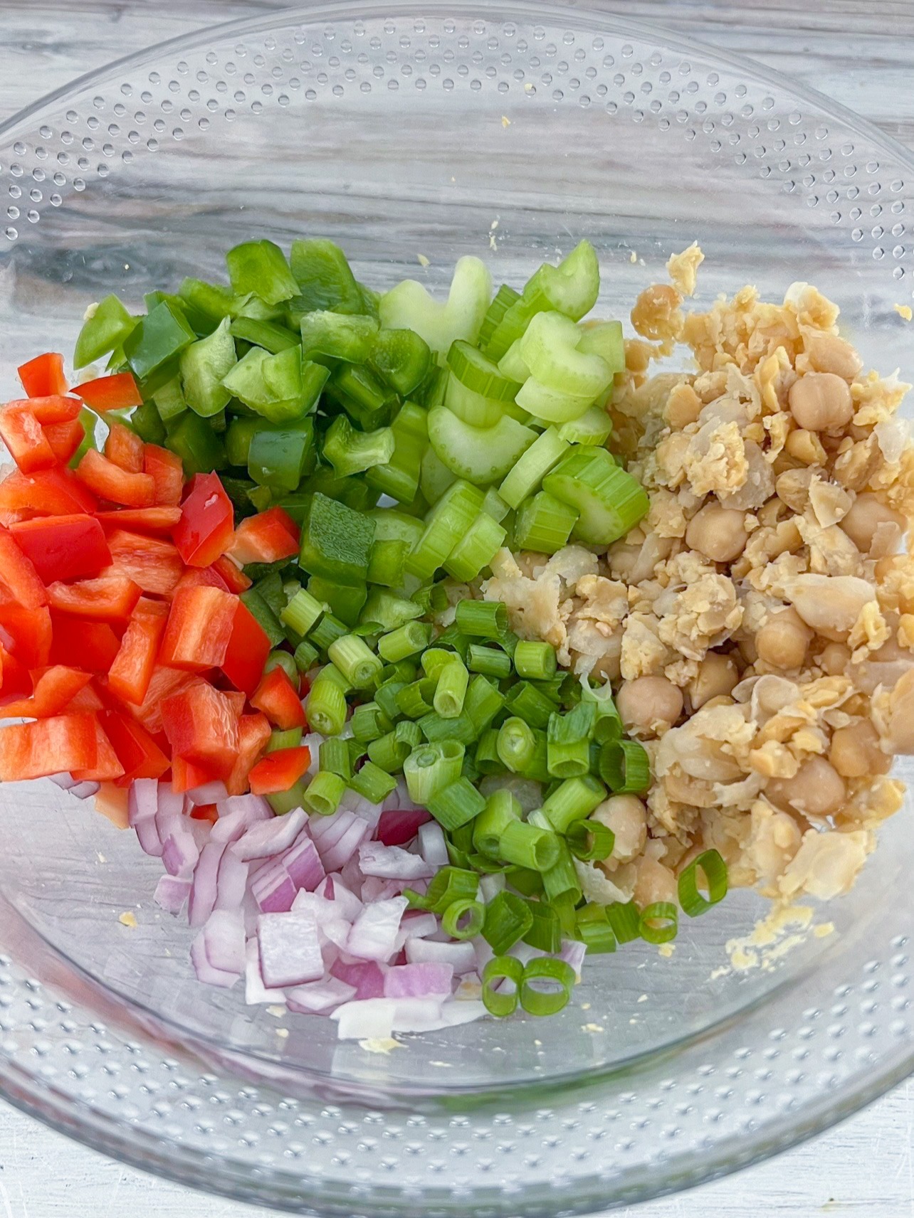 Veggies in a bowl with mashed chickpeas.