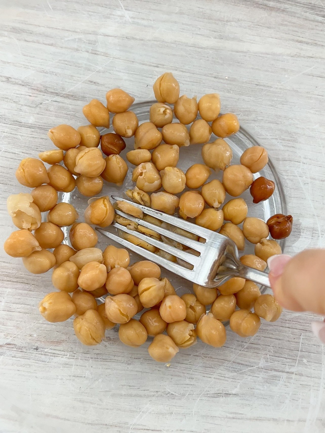 Mashing chickpeas with a fork.