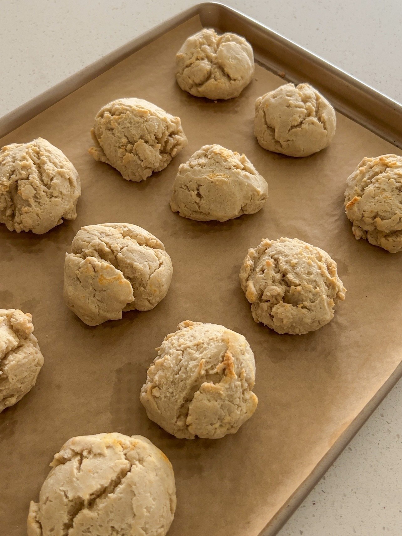 Baked drop biscuits on a sheet pan.