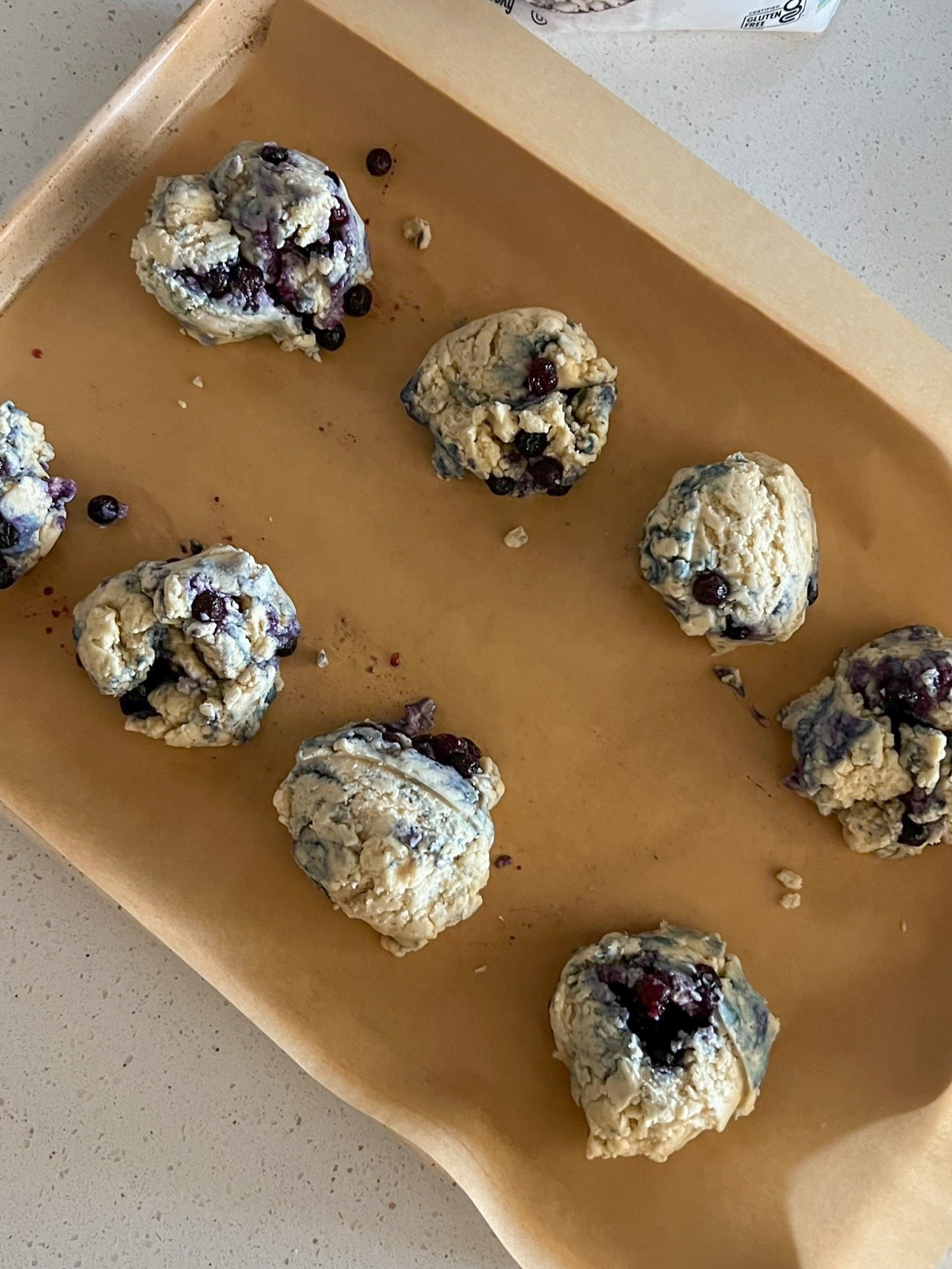 Biscuit dough dropped onto a prepared baking sheet. 